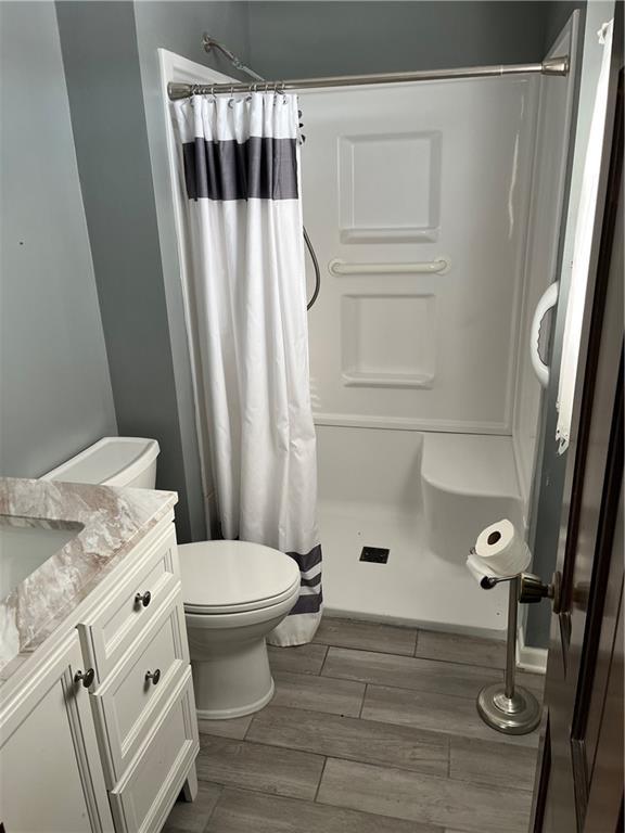 bathroom with curtained shower, vanity, and toilet