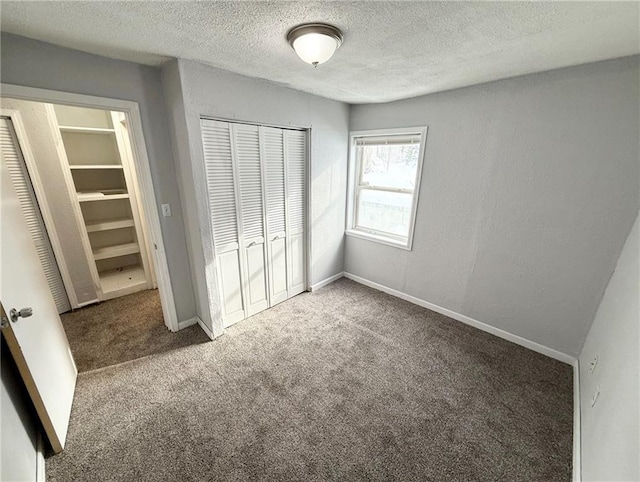 unfurnished bedroom featuring carpet, a textured ceiling, and a closet