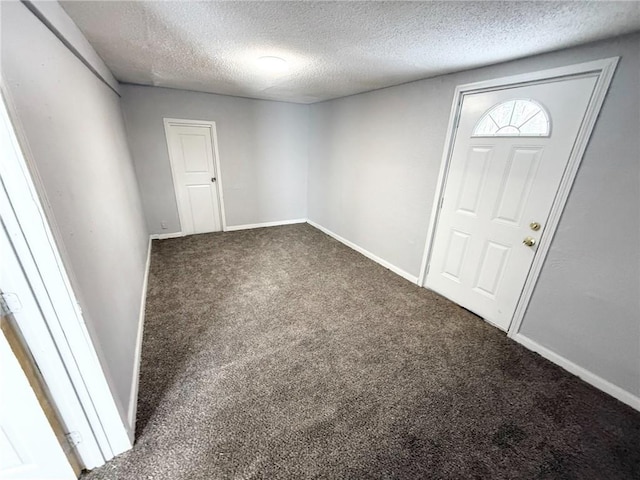 carpeted entrance foyer featuring a textured ceiling