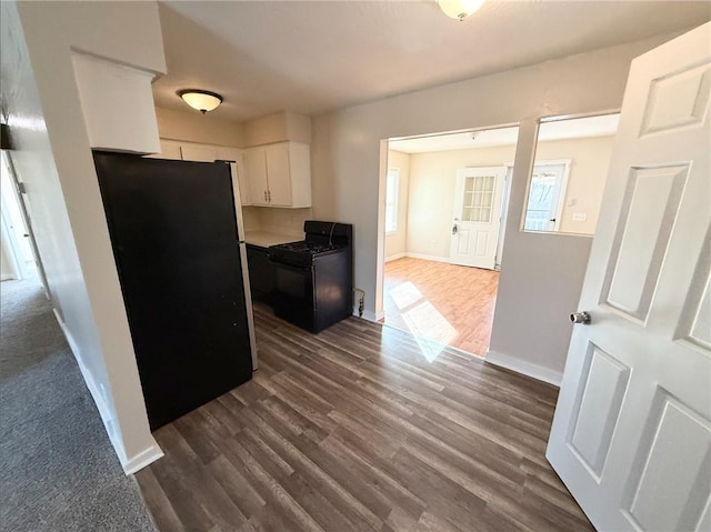 kitchen featuring dark hardwood / wood-style floors, white cabinetry, and black appliances