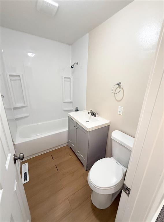 full bathroom featuring vanity, hardwood / wood-style flooring, toilet, and shower / washtub combination