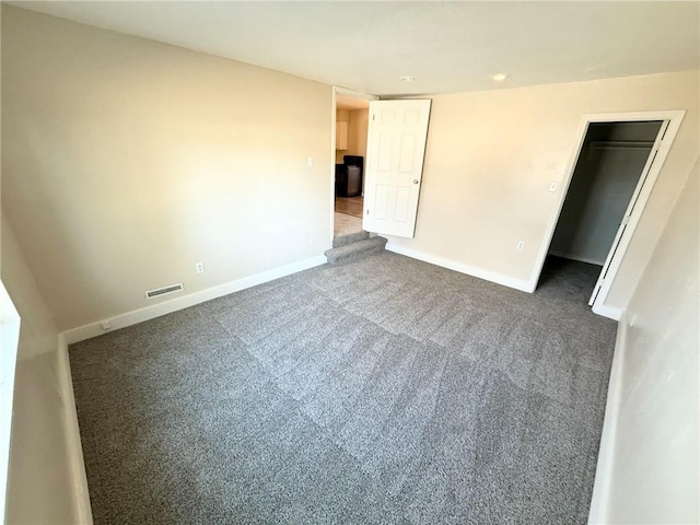 empty room featuring dark colored carpet