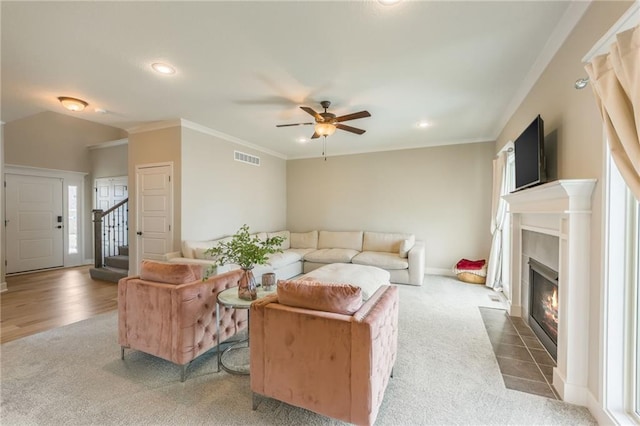 living room featuring crown molding, ceiling fan, and carpet