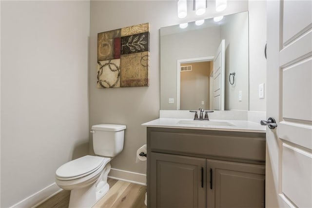 bathroom featuring hardwood / wood-style flooring, vanity, and toilet