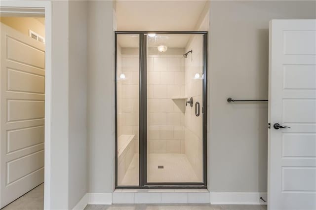 bathroom featuring a shower with door