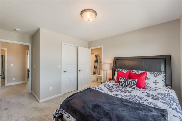 bedroom featuring ensuite bathroom and carpet flooring