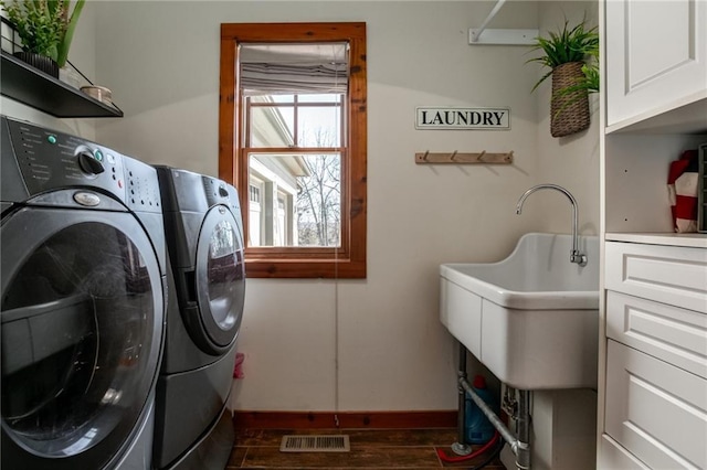 laundry room with cabinet space, baseboards, visible vents, dark wood-style flooring, and independent washer and dryer