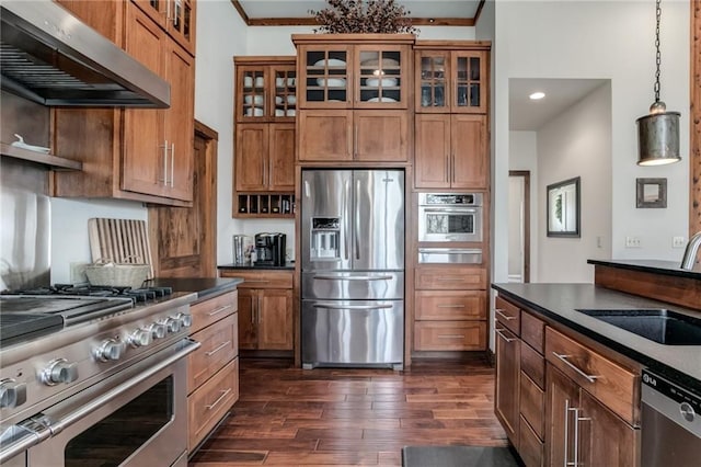 kitchen featuring appliances with stainless steel finishes, dark countertops, a sink, and under cabinet range hood