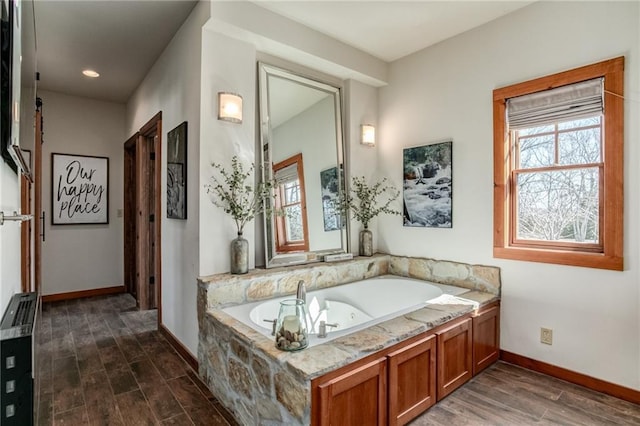 bathroom featuring recessed lighting, baseboards, a whirlpool tub, and wood finished floors