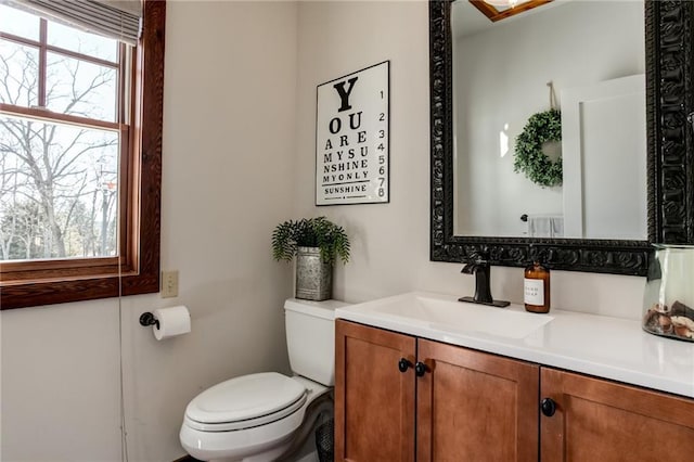 half bathroom featuring vanity and toilet