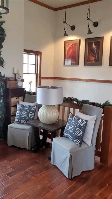 living area featuring wood finished floors and crown molding