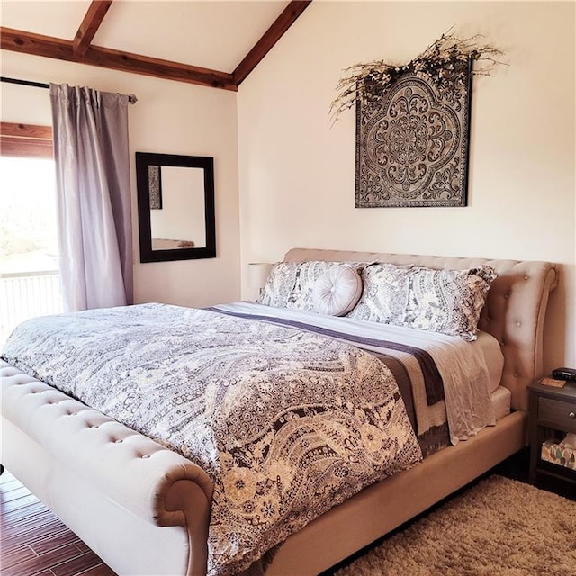 bedroom featuring radiator, vaulted ceiling with beams, and wood finished floors