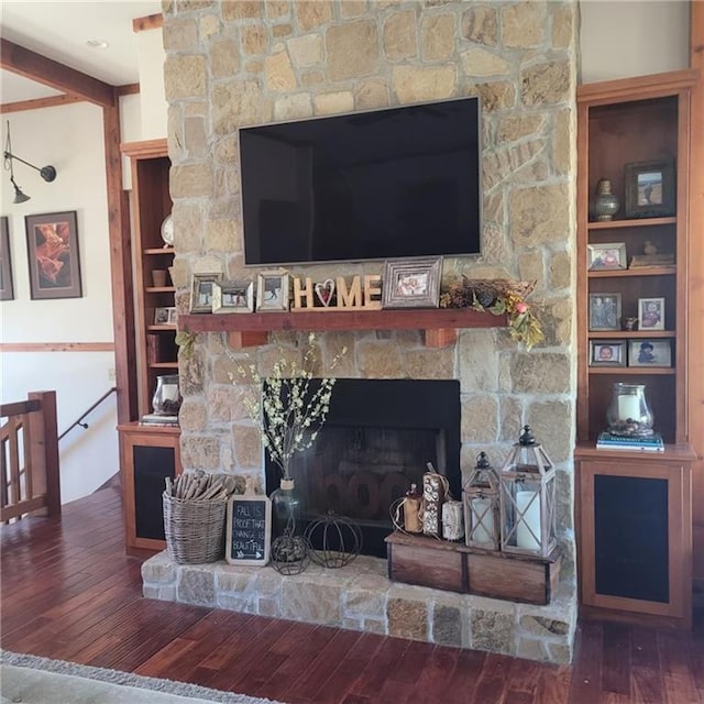 room details with built in shelves, a fireplace, wood finished floors, and beam ceiling