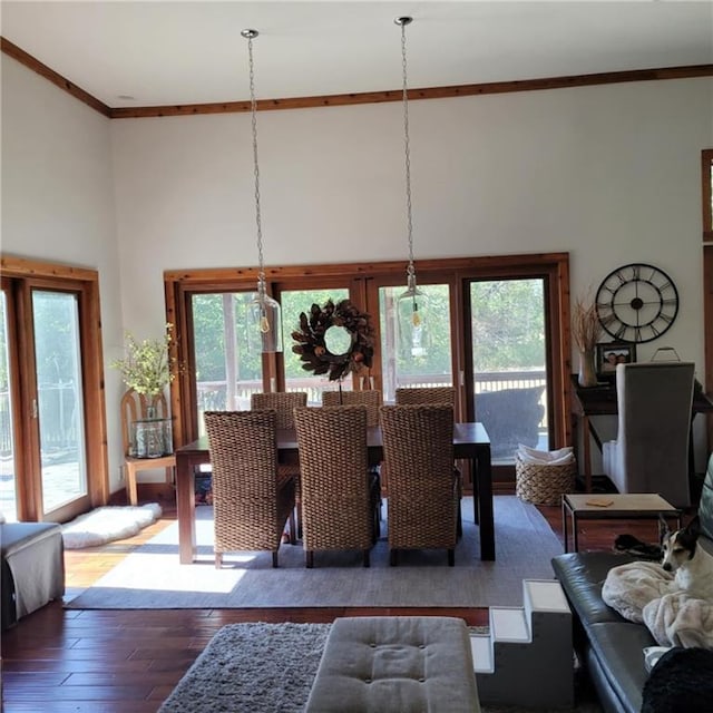 dining area featuring a wealth of natural light, crown molding, a high ceiling, and hardwood / wood-style flooring