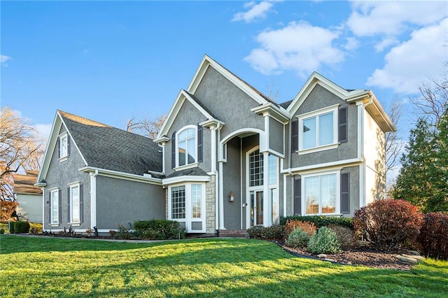 traditional home featuring a front yard and stucco siding