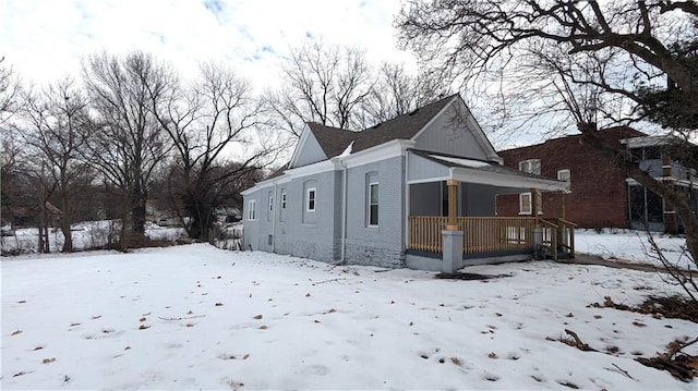 snow covered property featuring covered porch