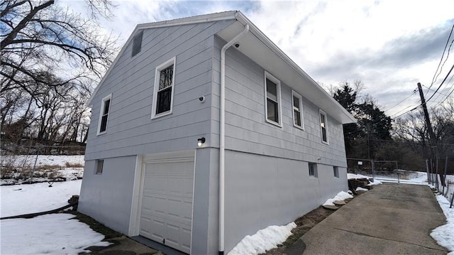 snow covered property with a garage