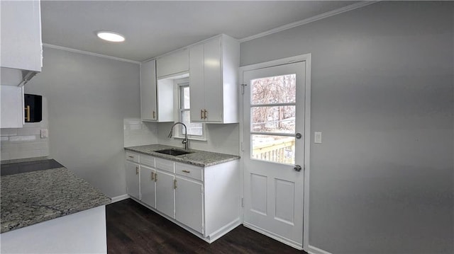 kitchen featuring sink, white cabinetry, dark hardwood / wood-style flooring, decorative backsplash, and black stovetop