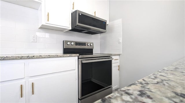 kitchen with light stone countertops, white cabinetry, appliances with stainless steel finishes, and decorative backsplash