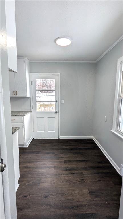 unfurnished dining area featuring crown molding and dark hardwood / wood-style floors