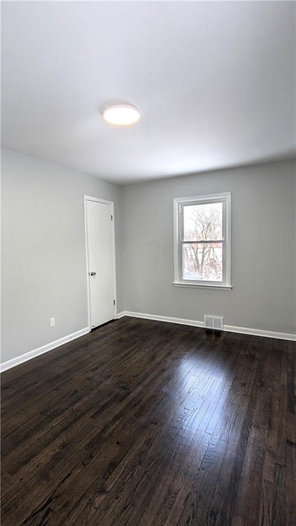 empty room with dark hardwood / wood-style floors