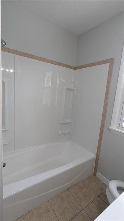 bathroom featuring tile patterned flooring, shower / bathing tub combination, and toilet