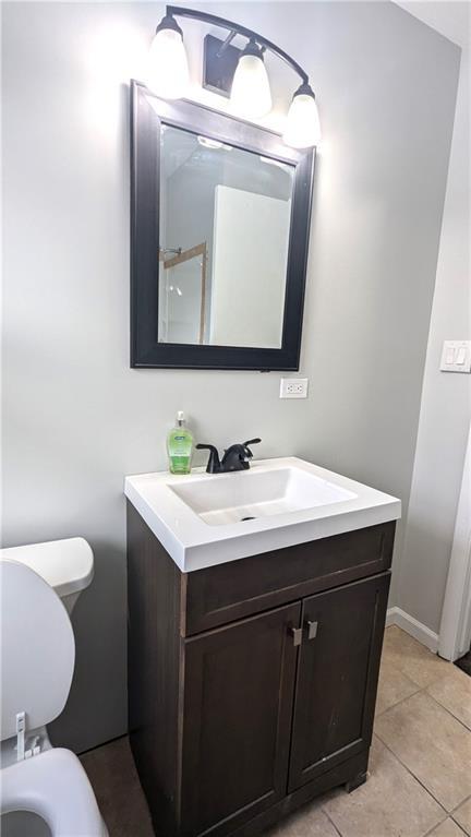 bathroom with vanity, tile patterned flooring, and toilet