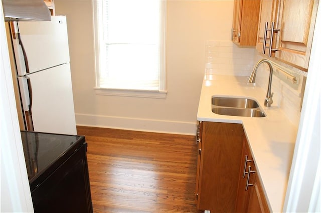 kitchen featuring black electric range oven, sink, white fridge, and dark wood-type flooring