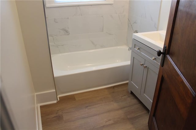 bathroom featuring wood-type flooring, vanity, and  shower combination