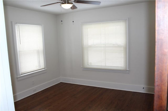 empty room with ceiling fan, dark wood-type flooring, and a wealth of natural light