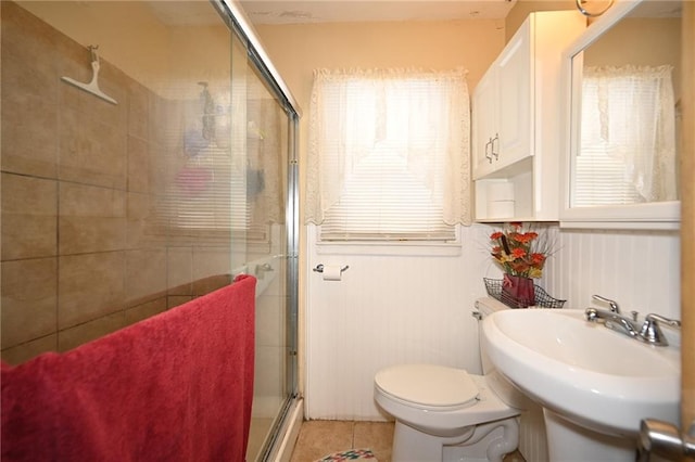 bathroom featuring tile patterned flooring, toilet, an enclosed shower, and sink