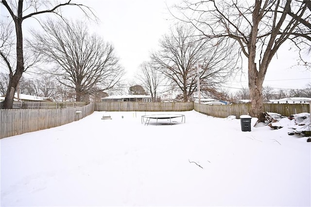 snowy yard featuring a trampoline