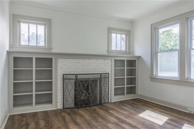 unfurnished living room with dark hardwood / wood-style flooring, crown molding, and a fireplace