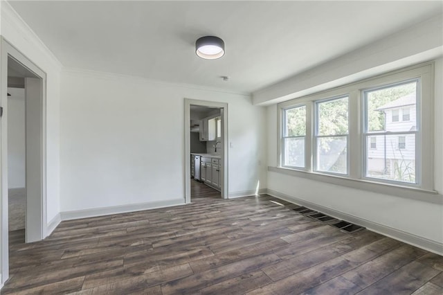 unfurnished room featuring crown molding, sink, and dark wood-type flooring