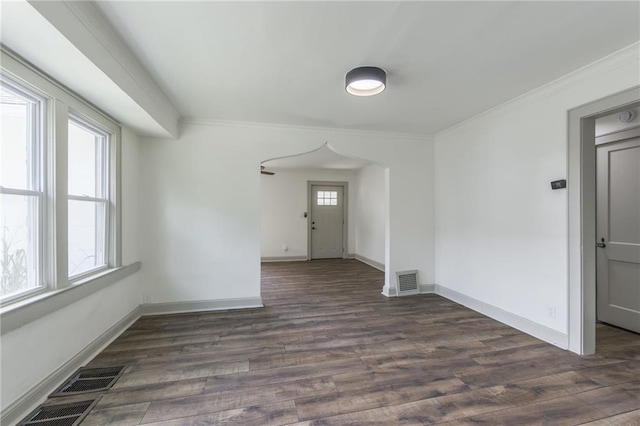 spare room with ornamental molding and dark wood-type flooring