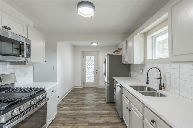 kitchen with white cabinets, appliances with stainless steel finishes, backsplash, and sink