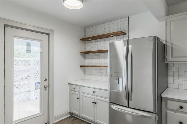 kitchen with white cabinets, stainless steel fridge, backsplash, and dark hardwood / wood-style floors