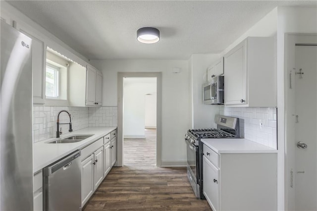 kitchen with decorative backsplash, sink, white cabinetry, and stainless steel appliances