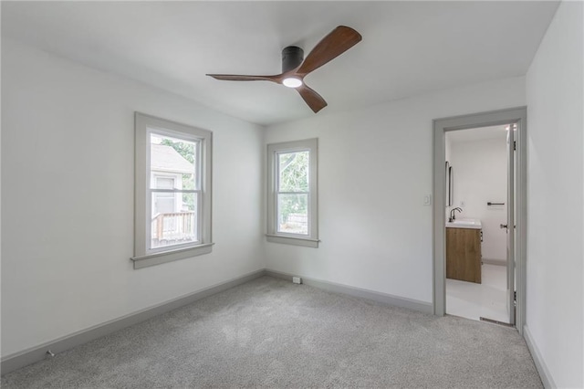 unfurnished bedroom with ceiling fan, sink, and light colored carpet