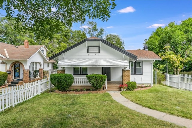 bungalow-style home featuring covered porch and a front lawn