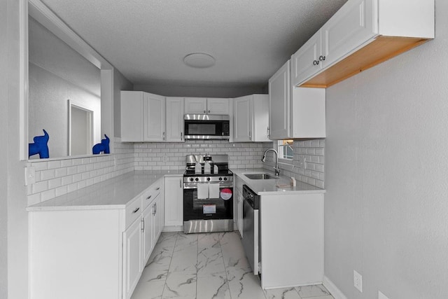 kitchen with sink, white cabinetry, and stainless steel appliances