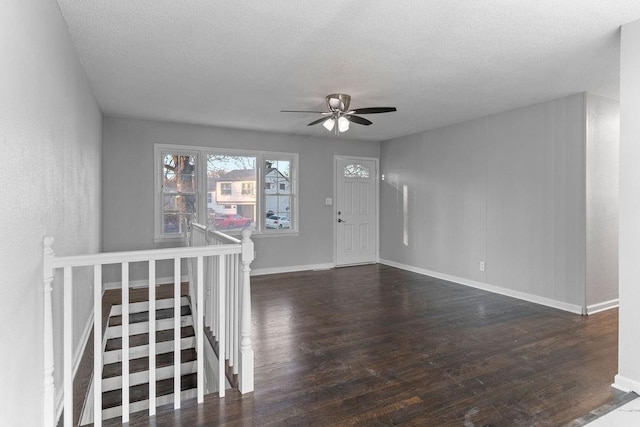 interior space with ceiling fan, dark wood-type flooring, and a textured ceiling