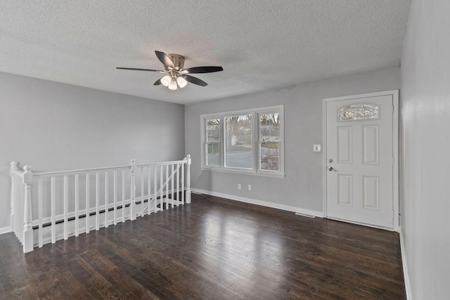 foyer with ceiling fan, a textured ceiling, and dark wood-type flooring