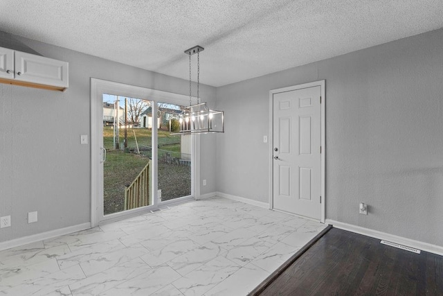 unfurnished dining area with a textured ceiling