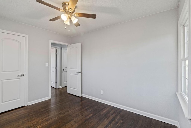 unfurnished bedroom with a textured ceiling, ceiling fan, and dark wood-type flooring