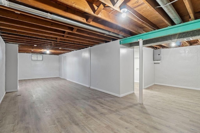 basement featuring electric panel and hardwood / wood-style floors