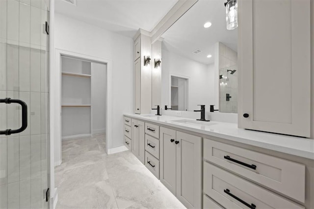 bathroom featuring a shower with door and vanity