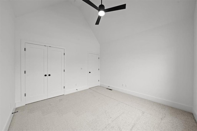 unfurnished bedroom with ceiling fan, light colored carpet, and high vaulted ceiling