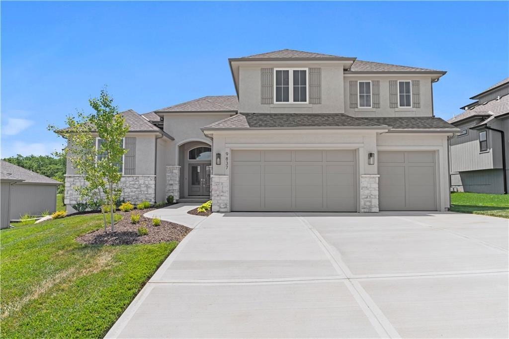 view of front of property with a garage and a front lawn