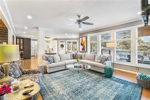 living room featuring ornate columns, crown molding, ceiling fan, and hardwood / wood-style flooring